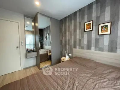 Modern bedroom with stylish decor and mirrored wardrobe in a cozy apartment.