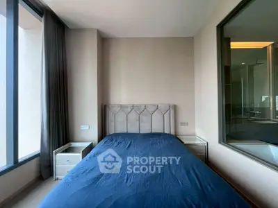 Modern bedroom with large window and stylish headboard in a contemporary apartment.