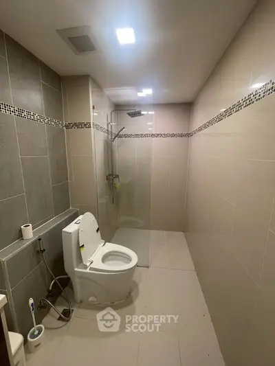 Modern bathroom with sleek design and glass shower enclosure in a contemporary home.