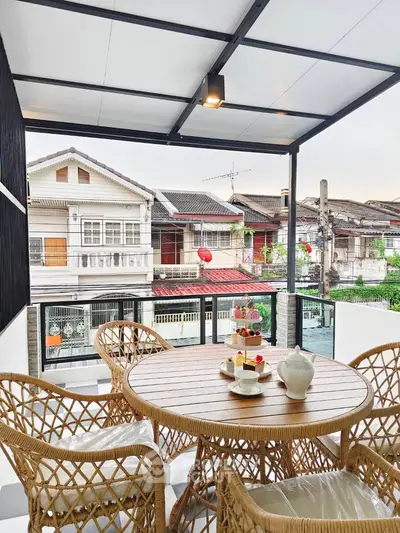 Charming balcony with stylish wicker furniture and scenic neighborhood view, perfect for relaxing outdoors.