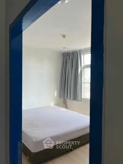 Cozy bedroom with natural light and minimalist decor, perfect for relaxation and comfort.