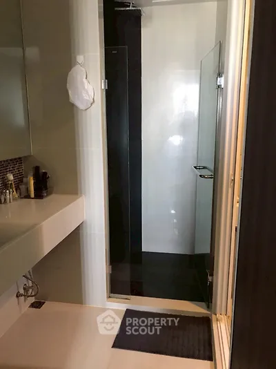 Modern bathroom with sleek shower and stylish sink area.