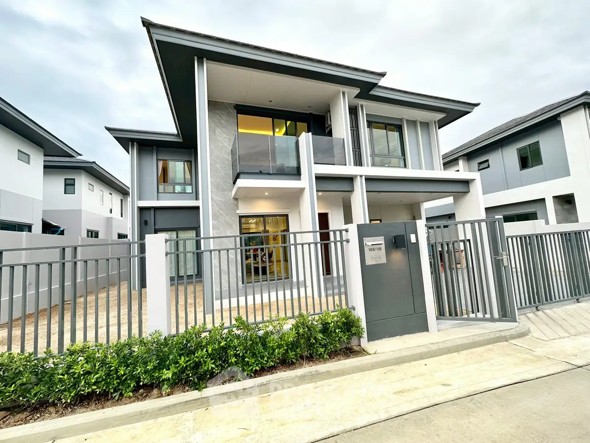 Modern two-story house with sleek design and spacious balcony in a suburban neighborhood.