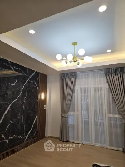 Elegant living room with modern chandelier and marble accent wall