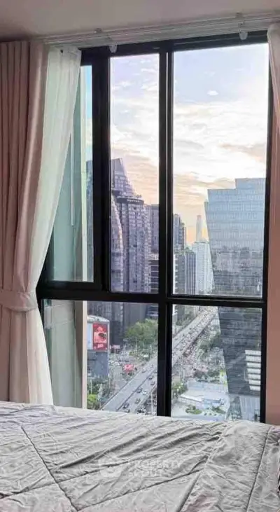 Stunning city view from a modern bedroom window in a high-rise apartment.