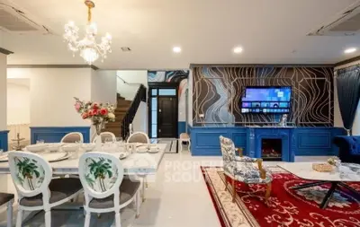 Luxurious living room with elegant dining area, ornate chandelier, and stylish decor in a modern home.