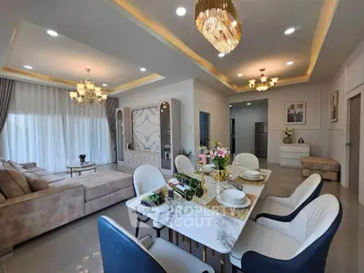 Luxurious open-plan living and dining area with elegant chandeliers and modern decor.