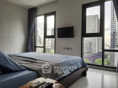 Modern bedroom with city view and wall-mounted TV in high-rise apartment