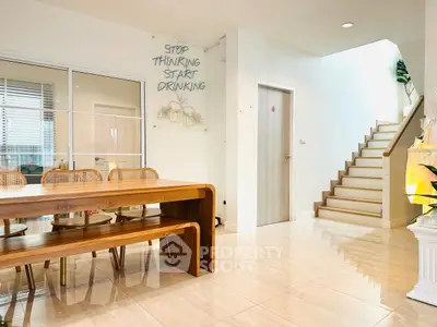 Modern dining area with wooden table and staircase in bright open space