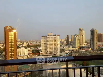 Stunning cityscape view from a high-rise balcony showcasing urban skyline at sunset.