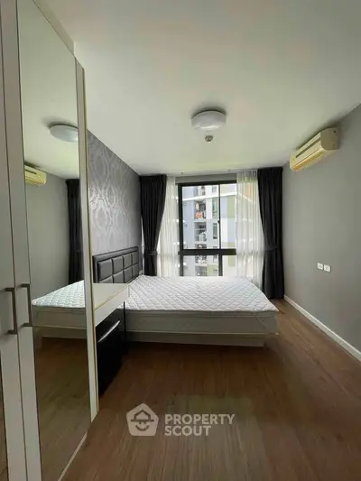 Modern bedroom with large window and stylish decor in urban apartment