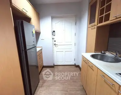 Charming kitchen with wooden cabinets and modern appliances in cozy apartment.