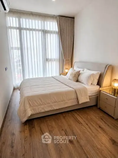 Elegant bedroom with large window and cozy decor in modern apartment
