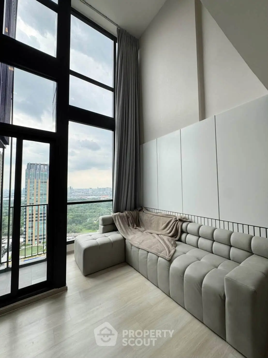Modern living room with floor-to-ceiling windows and stunning city view