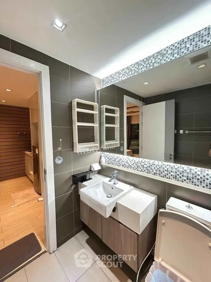 Modern bathroom with sleek fixtures and large mirror in contemporary home.