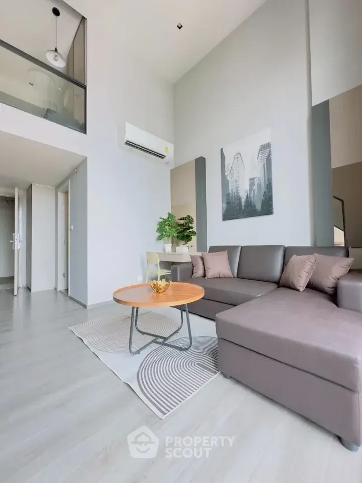 Modern living room with high ceiling and stylish decor in a contemporary apartment.