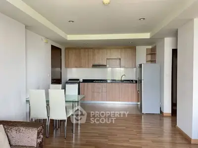 Modern open-layout kitchen with dining area and sleek appliances in a stylish apartment.