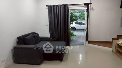 Modern living room with sleek black sofa and large window view