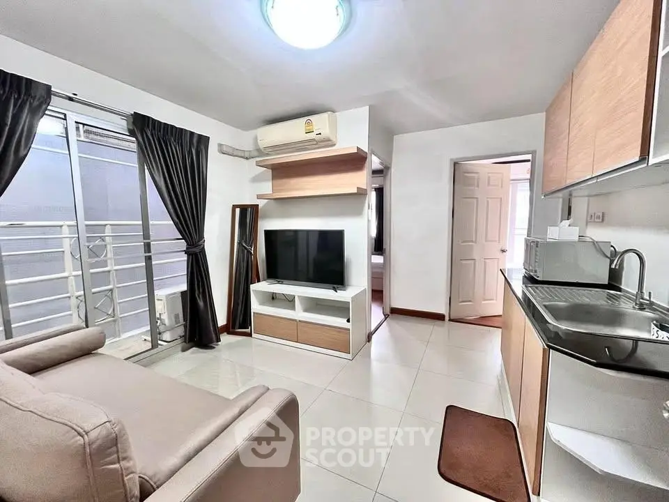 Modern living room with sleek furniture and open kitchen layout in a stylish apartment.