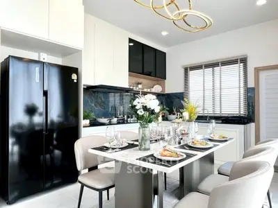 Modern kitchen with dining area, sleek black fridge, and elegant decor