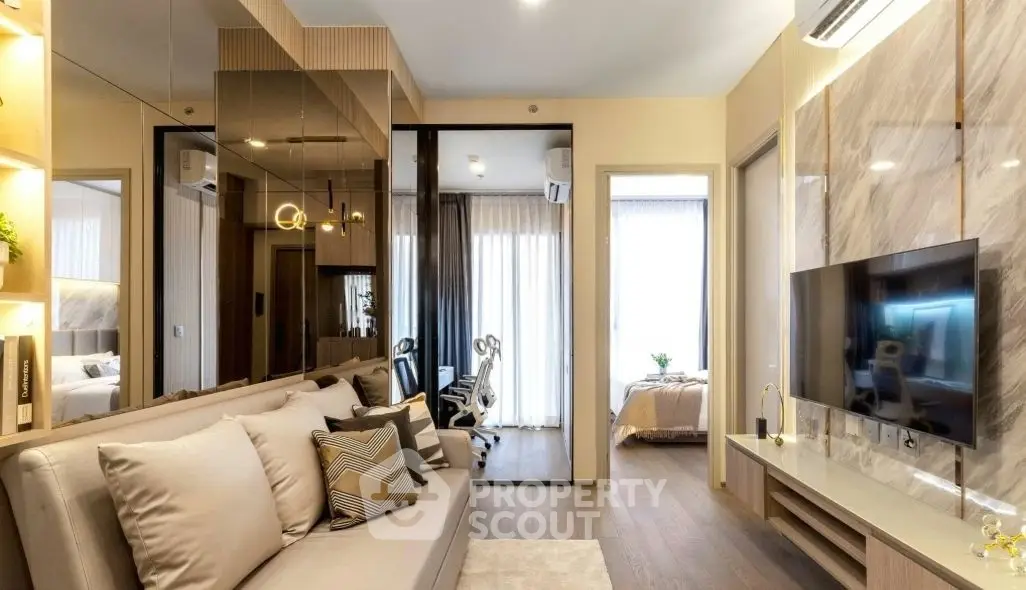 Modern living room with stylish decor and open layout leading to bedroom and study area.