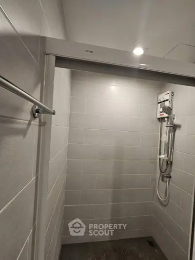 Modern bathroom shower area with sleek tiles and showerhead