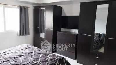 Modern bedroom with sleek dark furniture and natural light