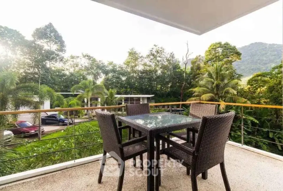 Spacious balcony with outdoor dining set and lush green view