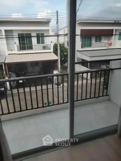 Modern balcony view overlooking residential street with contemporary houses.
