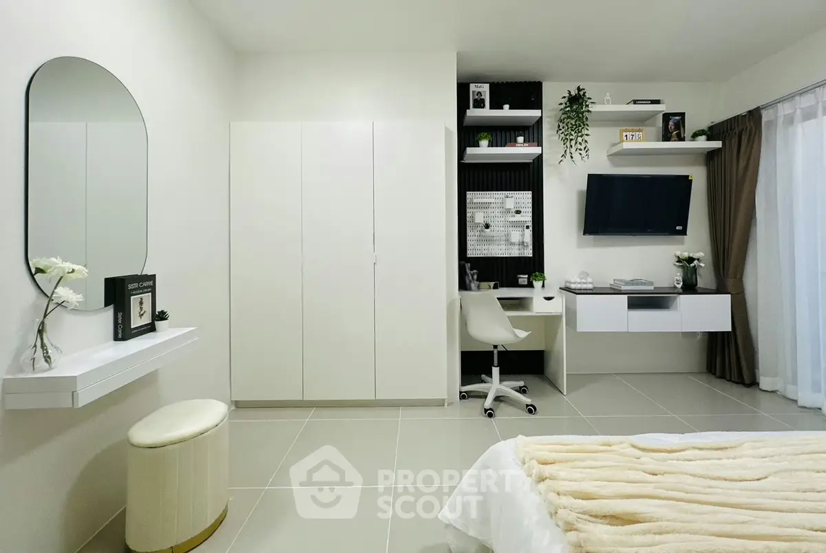 Modern bedroom with sleek design, featuring a study area, wall-mounted TV, and elegant decor.