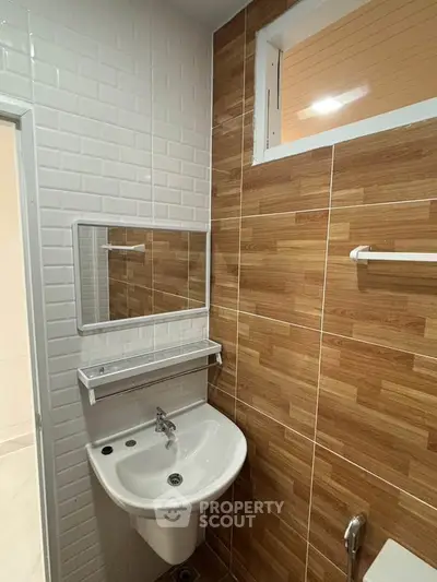 Modern bathroom with stylish wood tile accent wall and sleek white fixtures.