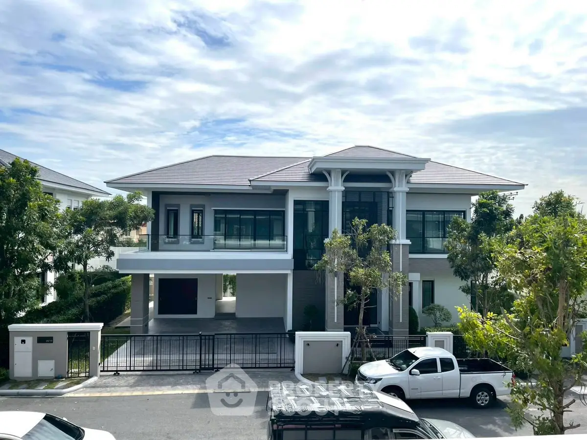 Stunning modern two-story house with spacious driveway and lush greenery