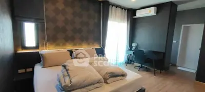 Modern bedroom with stylish decor and workspace, featuring elegant lighting and air conditioning.