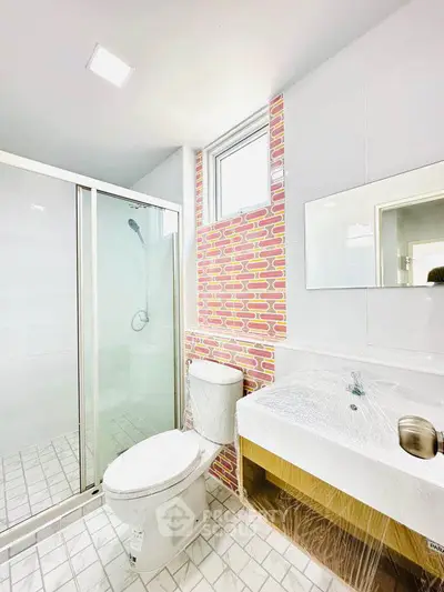 Modern bathroom with shower and stylish brick accent wall