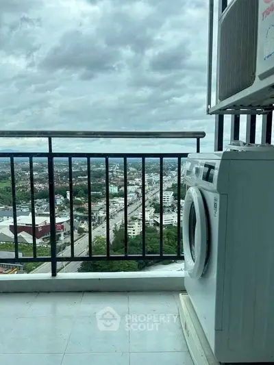 Stunning balcony view with washing machine overlooking cityscape and lush greenery.