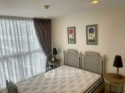 Cozy bedroom with elegant decor and large window for natural light