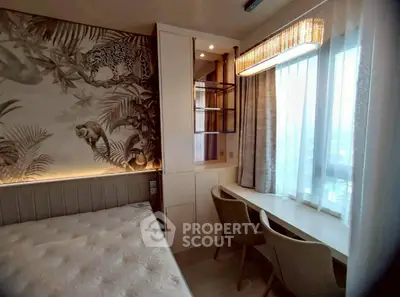 Stylish bedroom with jungle-themed wallpaper and cozy study nook by the window.