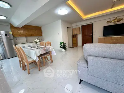 Spacious open-plan living and dining area with modern kitchen and elegant decor.
