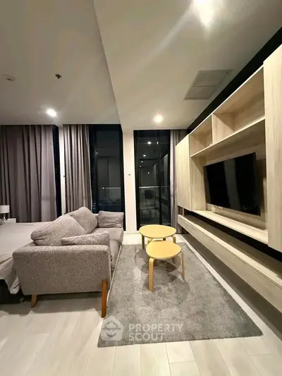 Modern living room with sleek furniture and large windows in a stylish apartment.