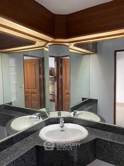 Elegant bathroom with modern corner sink and mirrored walls
