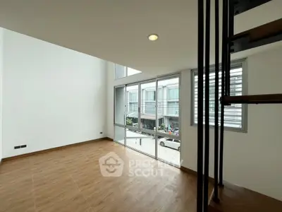 Spacious modern living room with large windows and wooden flooring