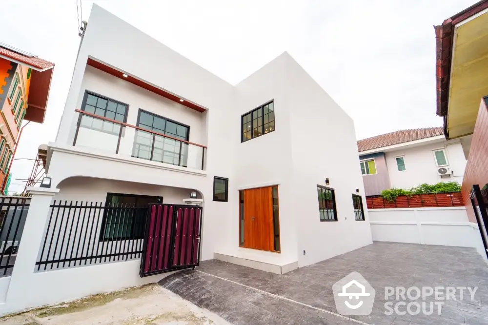 Modern two-story white house with spacious driveway and stylish wooden door