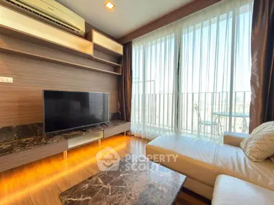 Modern living room with large TV, stylish furniture, and balcony view.