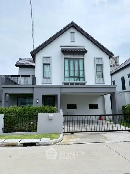 Modern two-story house with a spacious driveway and manicured lawn in a suburban neighborhood.