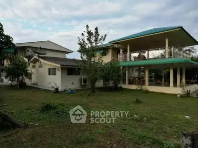 Spacious two-story home with large balcony and lush garden, perfect for family living.
