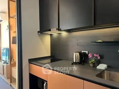 Modern kitchen with sleek cabinetry and built-in appliances, featuring a cozy open layout.