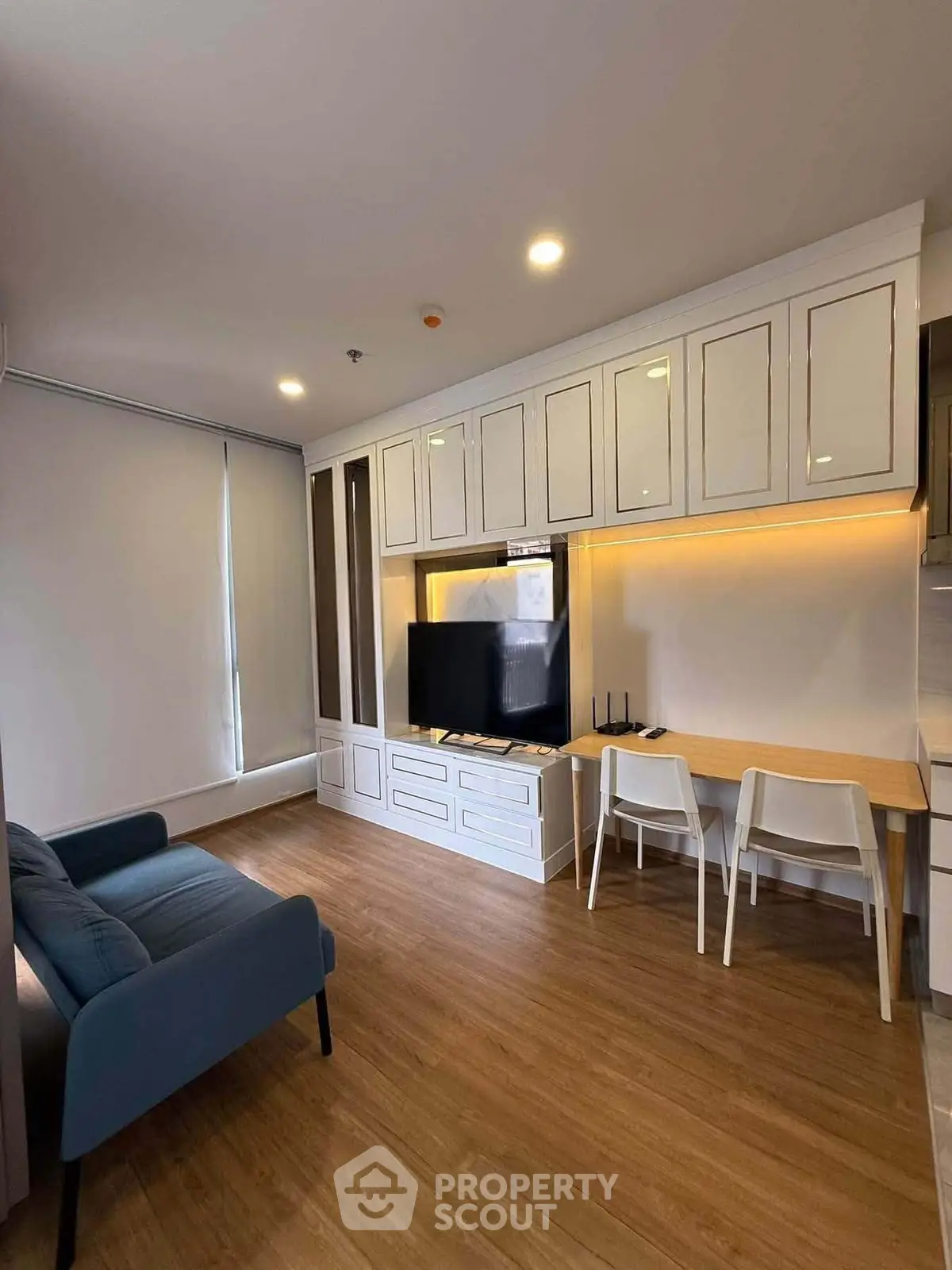 Modern living room with built-in cabinets and sleek furniture in a cozy apartment.