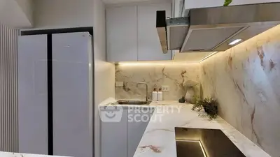 Modern kitchen with sleek marble countertops and built-in appliances, perfect for culinary enthusiasts.