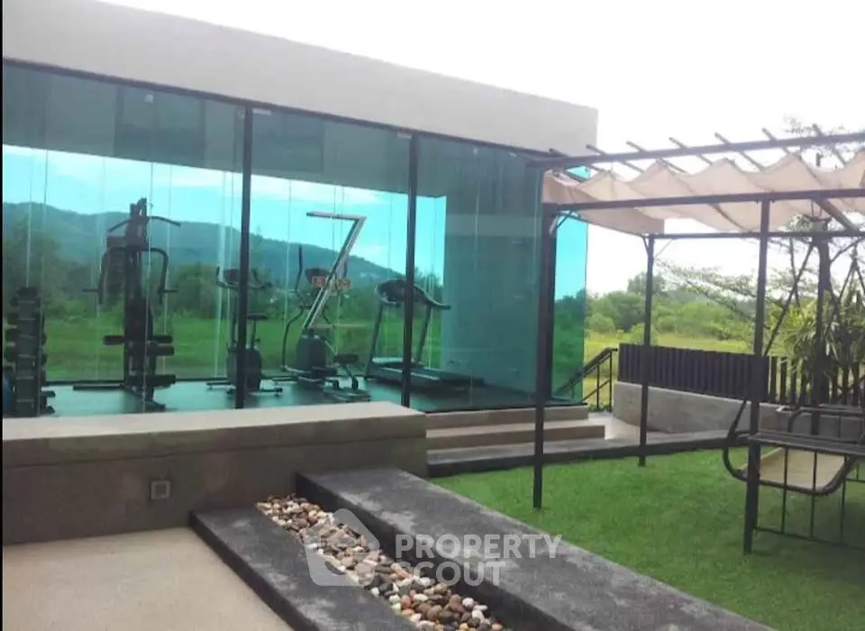 Modern gym with glass walls and scenic outdoor view in luxury property
