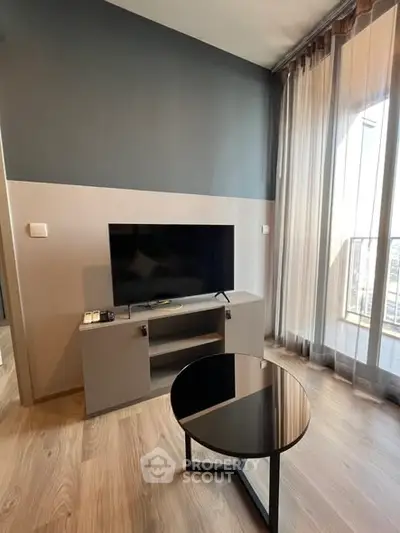 Modern living room with sleek TV stand and large window for natural light.